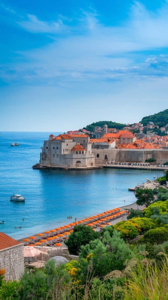 A lush, green hillside overlooking Dubrovnik's Old Town and its red-tiled rooftops, framed by the shimmering blue Adriatic Sea. This vibrant scene is quintessential of the Dubrovnik Croatia aesthetic.