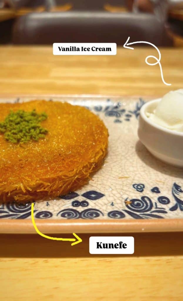A plate of künefe garnished with crushed pistachios next to a scoop of vanilla ice cream, with text labeling each item. This vibrant dessert display is perfect for an Istanbul Instagram story.
