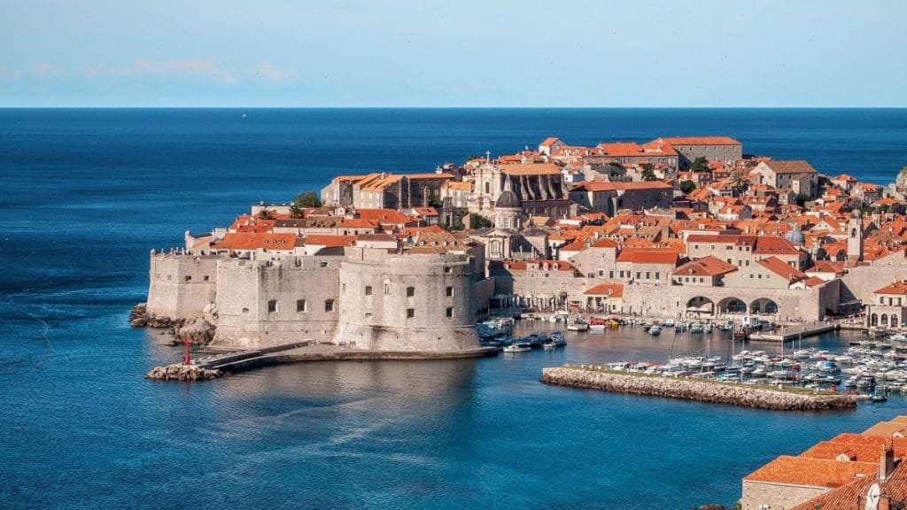 A breathtaking aerial view of Dubrovnik’s Old Town, showcasing its well-preserved medieval walls and terracotta rooftops against the deep blue Adriatic Sea. A must-see stop on any Croatia Summer Itinerary, perfect for history lovers and scenic views.
