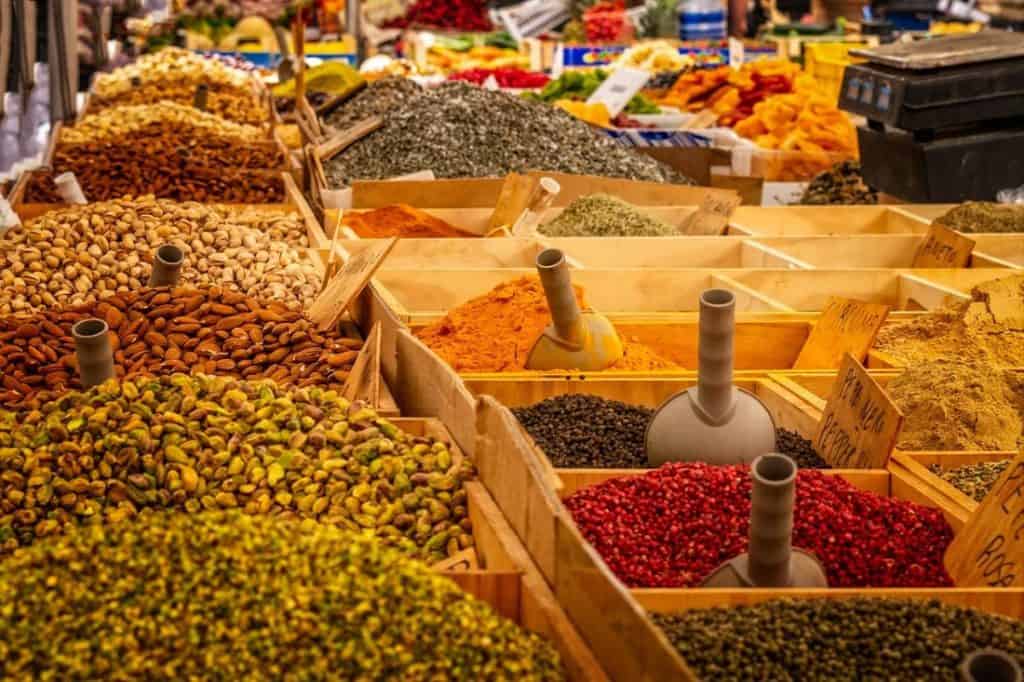 A vibrant open-air market in Zagreb filled with colorful spices, nuts, and dried fruits in wooden crates. A sensory delight and a great cultural stop on a Croatia Summer Itinerary for food lovers.