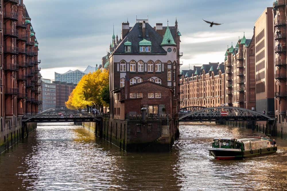 The historic Speicherstadt district in Hamburg, Germany, with its scenic canals, brick warehouses, and cruising boats—a top choice for couples seeking unique urban honeymoon destinations in Germany