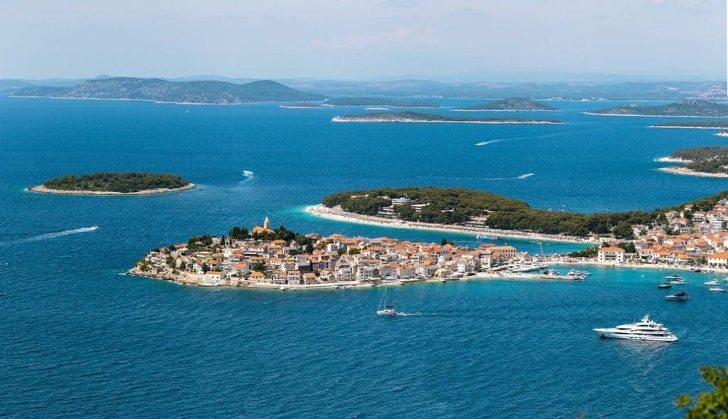 A picturesque aerial view of Lopud Island, featuring a charming coastal village, sandy beaches, and lush green hills surrounded by the sparkling Adriatic Sea. A hidden gem on a Croatia Summer Itinerary, ideal for relaxation and island hopping.