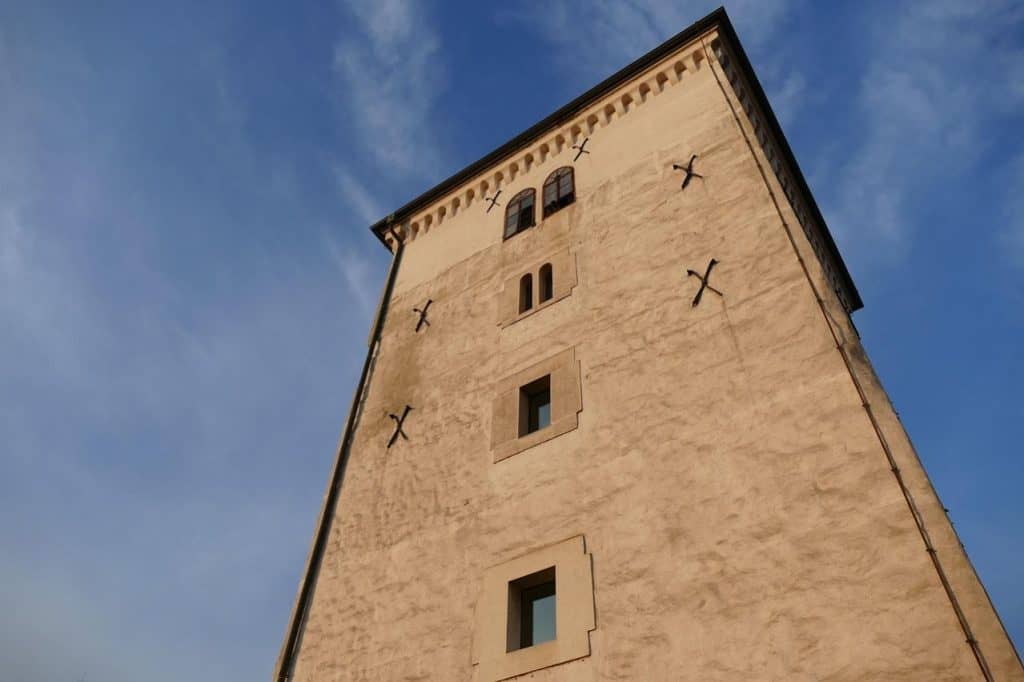A low-angle shot of Lotrščak Tower in Zagreb, a historic medieval fortress with a beige facade and iron reinforcements. A must-visit for history buffs on a Croatia Summer Itinerary, offering panoramic city views and the famous Grič Cannon.