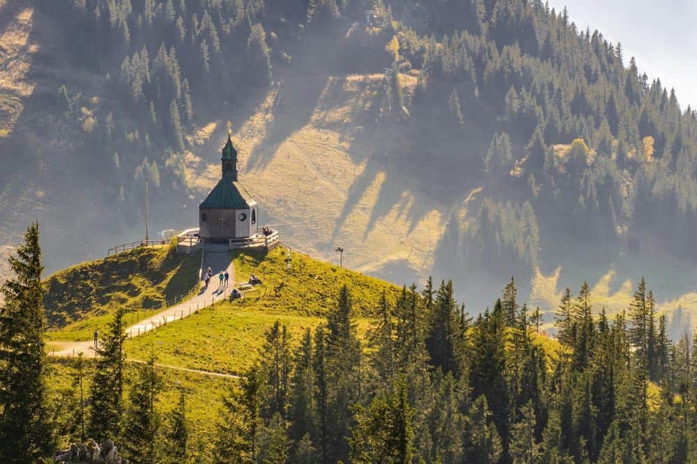 A quaint hilltop chapel surrounded by lush green forests in the Black Forest, Germany—an ideal spot for couples exploring honeymoon destinations in Germany known for their serene natural beauty