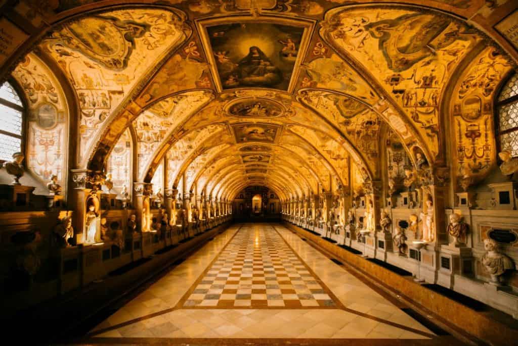The breathtaking Antiquarium hall inside the Munich Residenz, with its grand arched ceilings, intricate frescoes, and rows of statues illuminated by warm lighting. A former royal palace, the Residenz is a must-visit historical site and one of the most impressive cultural attractions in "Things to do in Munich."
