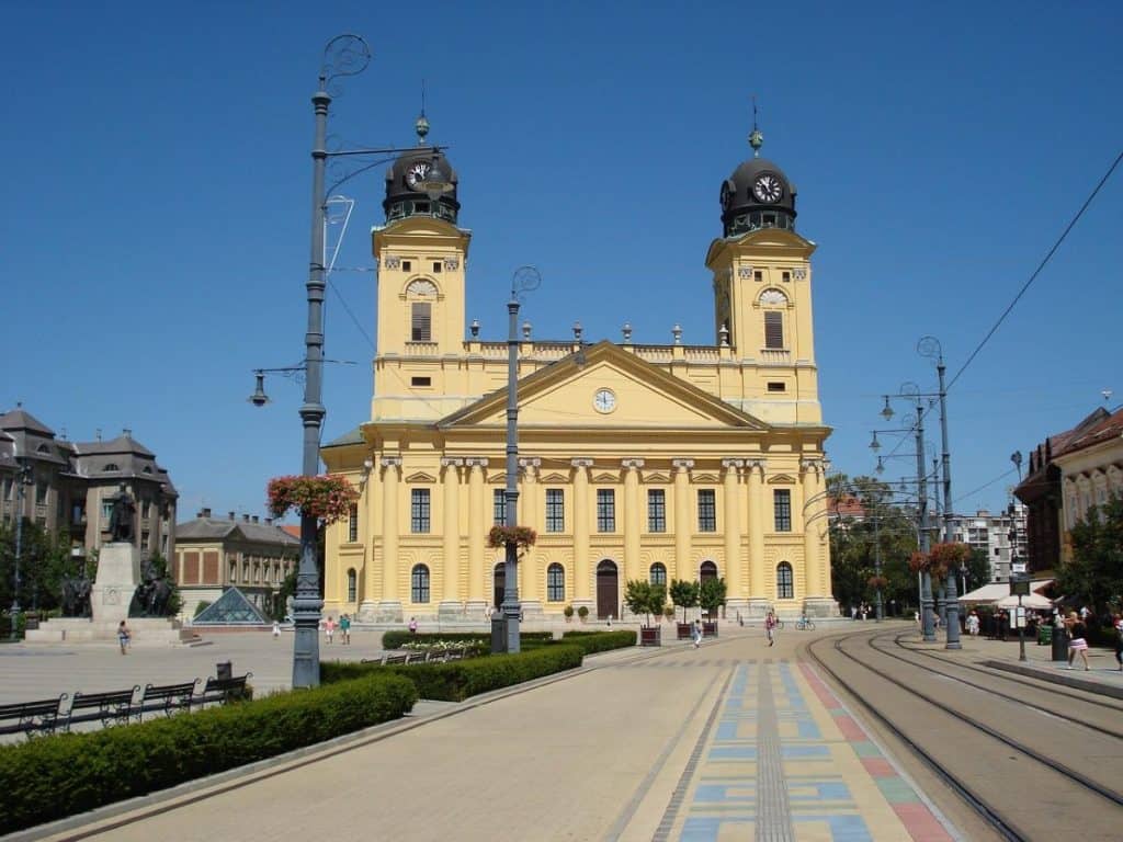 The iconic yellow Great Reformed Church of Debrecen under a clear blue sky, highlighting why this Hungarian city is a fantastic budget-friendly option for Cheap Travel Destinations in Europe Summer.