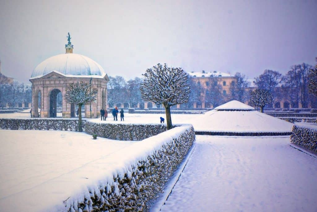 The snow-covered Hofgarten in Munich, showcasing neatly trimmed hedges, bare trees, and the elegant Diana Temple under a wintry sky, an ideal spot to visit during a Munich 2 Day Itinerary.