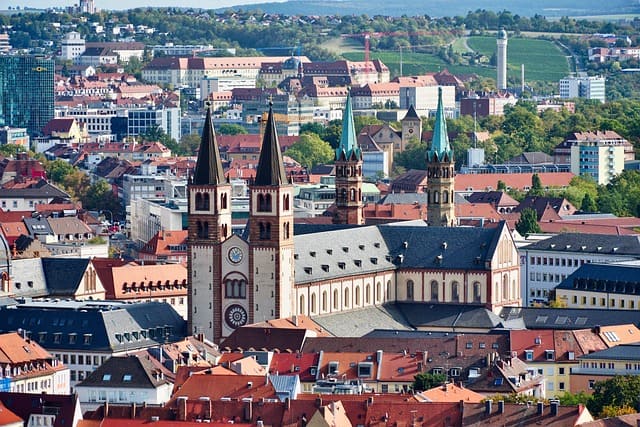 Würzburg Old Main Bridge, Bavaria, Germany – A panoramic view of Würzburg’s Old Main Bridge in Bavaria, Germany, spanning the Main River. The bridge is lined with statues and connects to the city’s historic district, surrounded by red-roofed buildings and towering church spires. This historic landmark is a must-see for Bavaria Germany Travel.