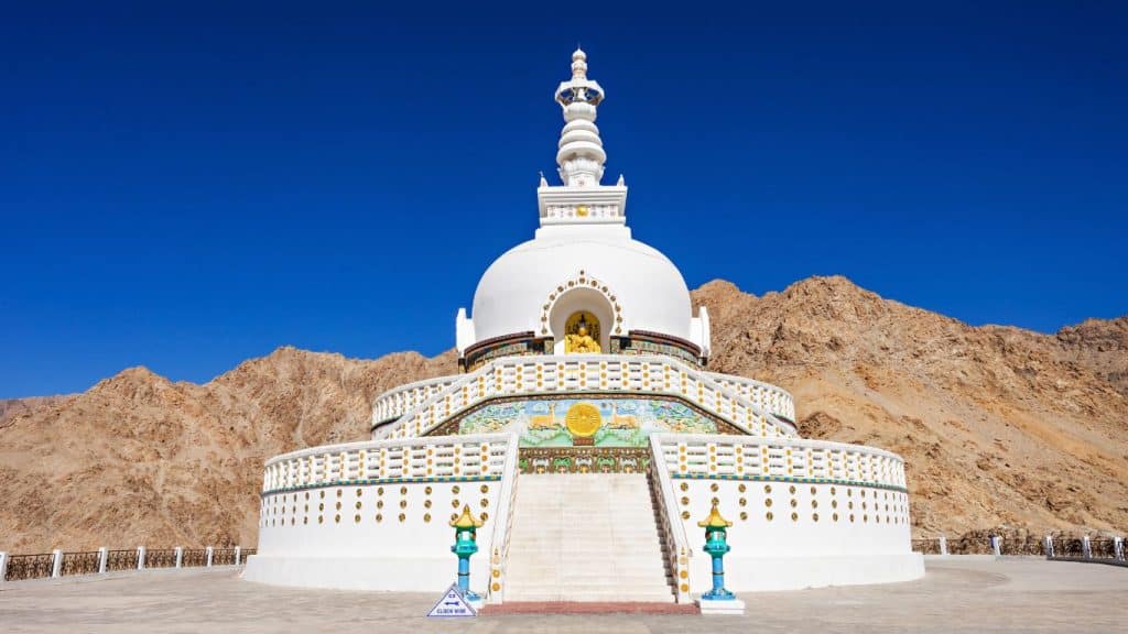 Majestic white-domed Shanti Stupa in Leh with colorful murals and symmetrical steps against a rocky mountain backdrop, a peaceful pause in any leh ladakh itinerary.