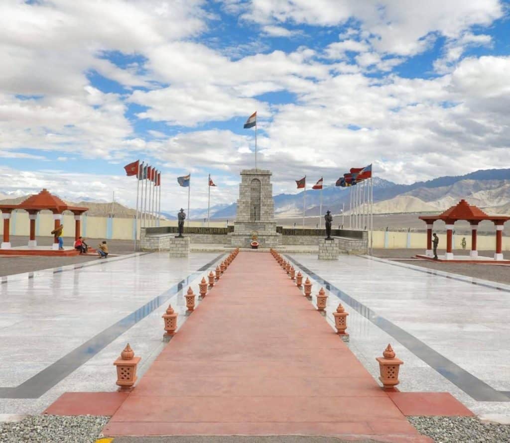  Wide-angle view of the Hall of Fame memorial in Leh, showcasing a symmetrical layout with flags, soldier statues, and mountain views—an inspiring stop in a leh ladakh itinerary.